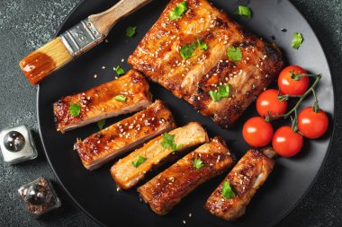 Barbekü soslu bir tabakta servis edilen sıcak ızgara pirzola. Üst Manzara. Boşluğu kopyala.