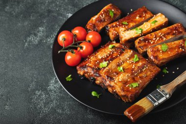 Barbekü soslu bir tabakta servis edilen sıcak ızgara pirzola. Üst Manzara. Boşluğu kopyala.