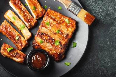 Barbekü soslu bir tabakta servis edilen sıcak ızgara pirzola. Üst Manzara. Boşluğu kopyala.