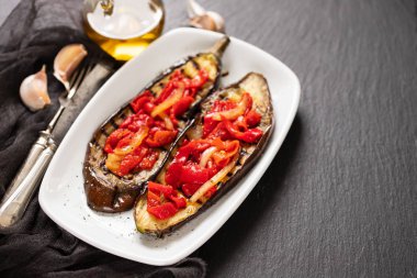 Beyaz çanak üzerinde kırmızı biber ile ızgara patlıcan