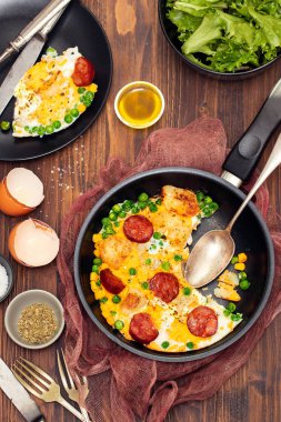patates, bezelye ve tütsülenmiş sosis ile karışık yumurta