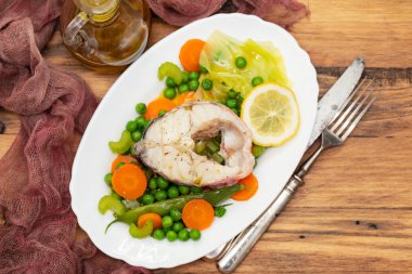 haşlanmış balık haşlanmış sebze ve beyaz çanak limon ile