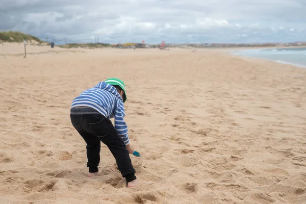 Çocuk kum ile kumsalda oynarken
