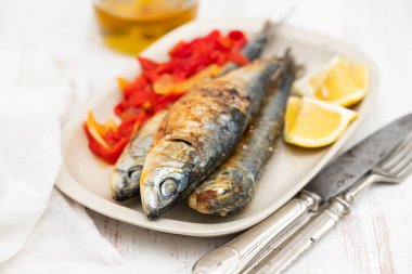 kırmızı biber ve limon çanak üzerinde ızgara sardalya