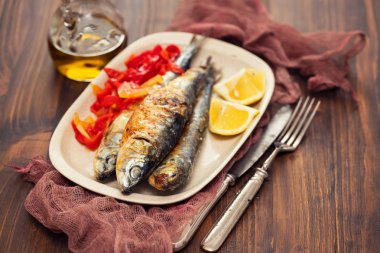 kırmızı biber ve limon çanak üzerinde ızgara sardalya