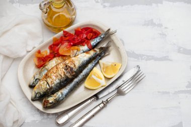 kırmızı biber ve limon çanak üzerinde ızgara sardalya