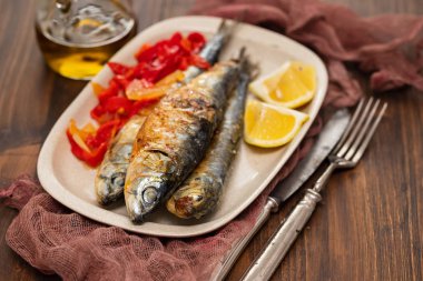 kırmızı biber ve limon çanak üzerinde ızgara sardalya