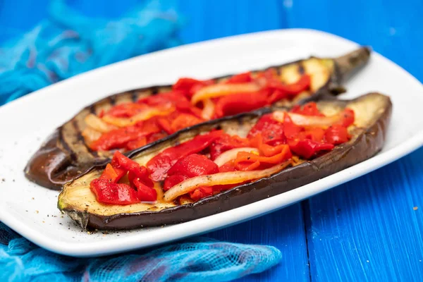 Beyaz çanak üzerinde kırmızı biber ile ızgara patlıcan