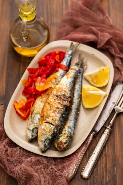 kırmızı biber ve limon çanak üzerinde ızgara sardalya