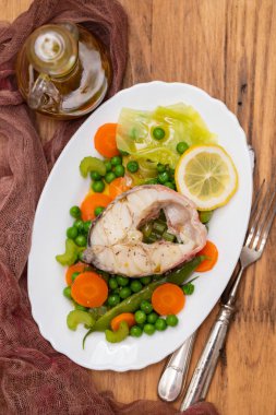 haşlanmış balık haşlanmış sebze ve beyaz çanak limon ile