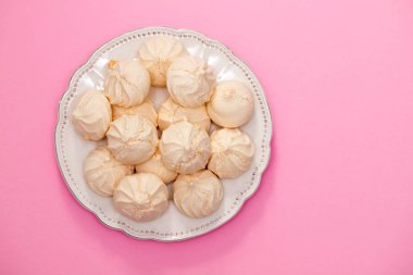 merengues çanak üzerinde pembe bir arka plan üzerinde