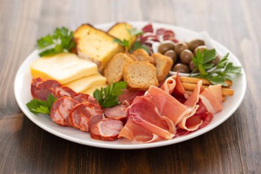 Beyaz çanak üzerinde füme et ile peynir