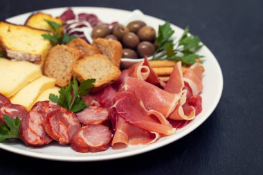 prosciutto ve tütsülenmiş sosis beyaz çanak üzerinde peynir