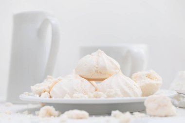 Beyaz arka plan üzerinde beyaz tabakta merengues