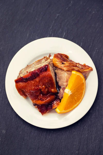 Maialino Arrosto Con Arancia Placca Bianca Fondo Nero — Foto Stock