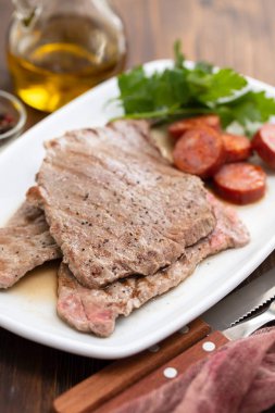 Beyaz çanak üzerinde füme soslu ızgara et