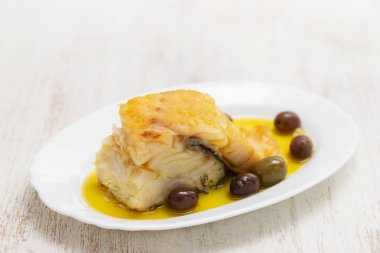 zeytin ve zeytinyağı beyaz çanak üzerinde kızarmış morina balığı