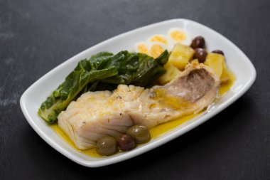 lahana, patates ve zeytin çanak üzerinde morina balığı