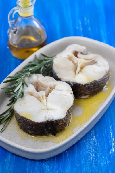 boiled fish with rosemary and olive oil in dish