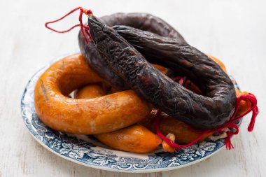 Seramik arka planda beyaz çanak üzerinde Portekizli füme sosis