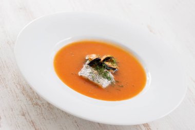 Beyaz ahşap arka planda beyaz plaka balık çorbası