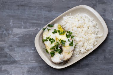 Seramik BAC üzerinde çanak maydanoz ve haşlanmış pirinç ile haşlanmış levrek