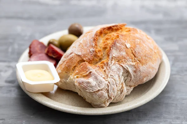 Pan con mantequilla, aceitunas y salchichas ahumadas en el plato en madera b —  Fotos de Stock