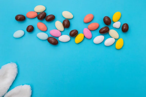 Primer plano de huevo de chocolate y gotas de caramelo sobre fondo azul —  Fotos de Stock