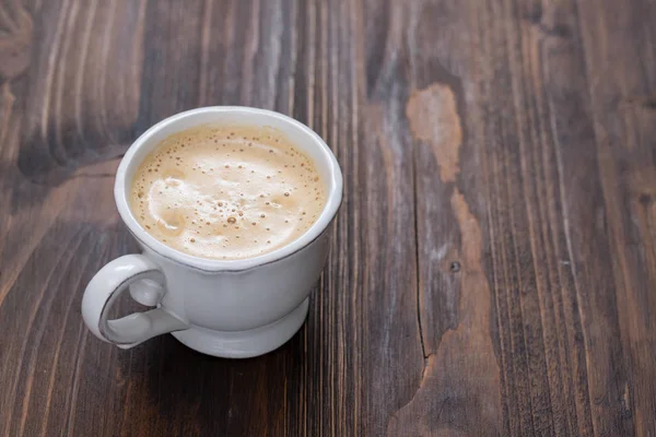 Eine Tasse Kaffee auf altem Holzgrund — Stockfoto