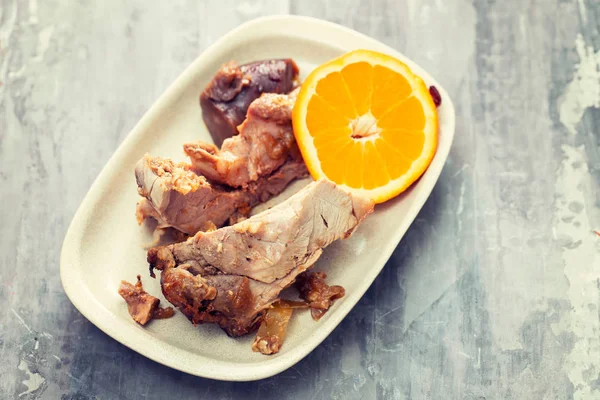 Carne assada com laranja no prato branco — Fotografia de Stock