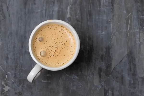 Een kopje koffie op grijze keramische achtergrond — Stockfoto