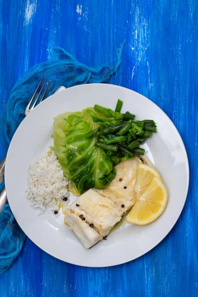 Gekochter Kabeljau mit Reis und Gemüse auf weißem Teller — Stockfoto
