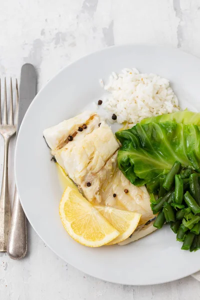 Gekochter Kabeljau mit Reis und Gemüse auf weißem Teller — Stockfoto