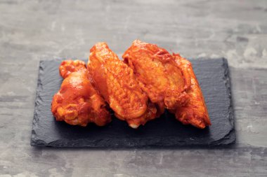 seramik arka plan üzerinde siyah tahta üzerinde marine tavuk