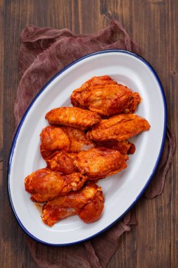 kahverengi ahşap arka plan üzerinde beyaz çanak üzerinde marine tavuk