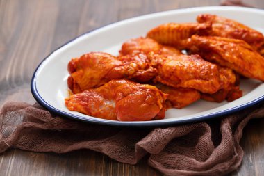 kahverengi ahşap arka plan üzerinde beyaz çanak üzerinde marine tavuk