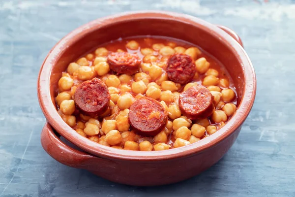 Pois chiches à la saucisse fumée dans un plat en céramique — Photo