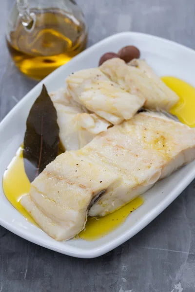 Boiled cod fish with olive oil on white dish on ceramic backgrou — Stock Photo, Image