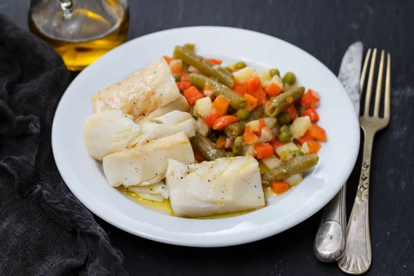 Cozido bacalhau peixe com legumes fervidos na placa branca em preto c — Fotografia de Stock