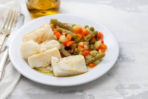 Boiled cod fish with boiled vegetables on white plate on ceramic — Stock Photo, Image