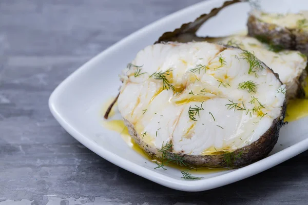 Peixe fervido com azeite e folha de louro em prato branco — Fotografia de Stock