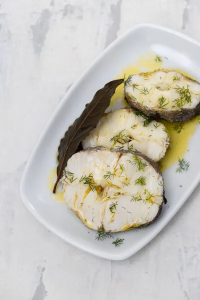 Gekochter Fisch mit Olivenöl und Lorbeerblatt in weißer Schale — Stockfoto