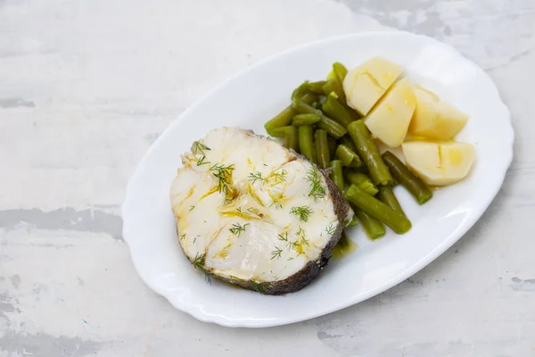 Vařené ryby se zelenými fazolemi a vařenými bramborami na bílém nádobí — Stock fotografie