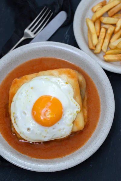 Typowy portugalski danie Francesinha w naczyniu na czarnym ceramicznym BAC — Zdjęcie stockowe