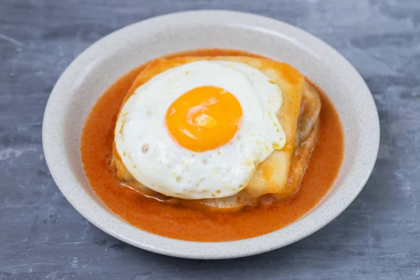 typical portuguese dish francesinha in dish on ceramic backgroun