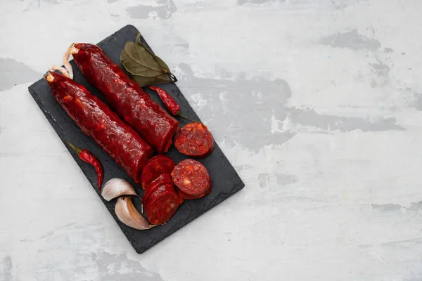 Spanisch geräucherte Wurst Chorizo auf schwarzer Keramikplatte — Stockfoto
