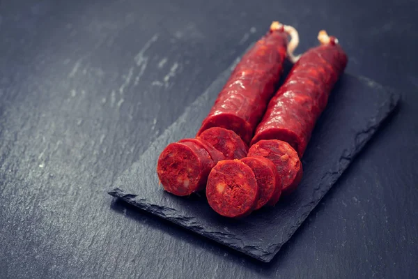 Chorizo de saucisses fumées espagnoles sur carton céramique noire — Photo