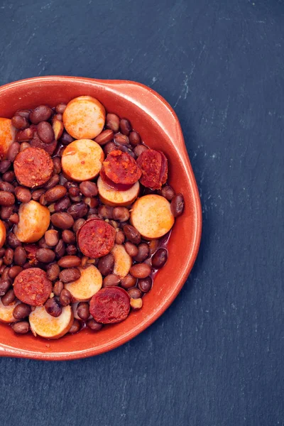 Haricots avec saucisses fumées et saucisses dans un plat en céramique — Photo