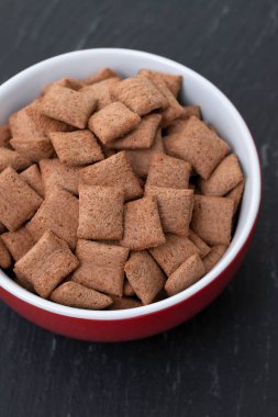 Seramik arka planda kırmızı kase çikolata yastıklar