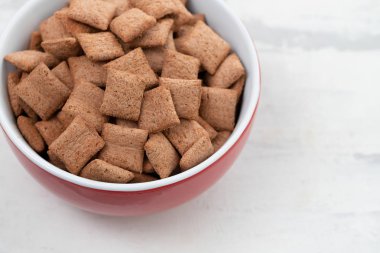 Seramik arka planda kırmızı kase çikolata yastıklar